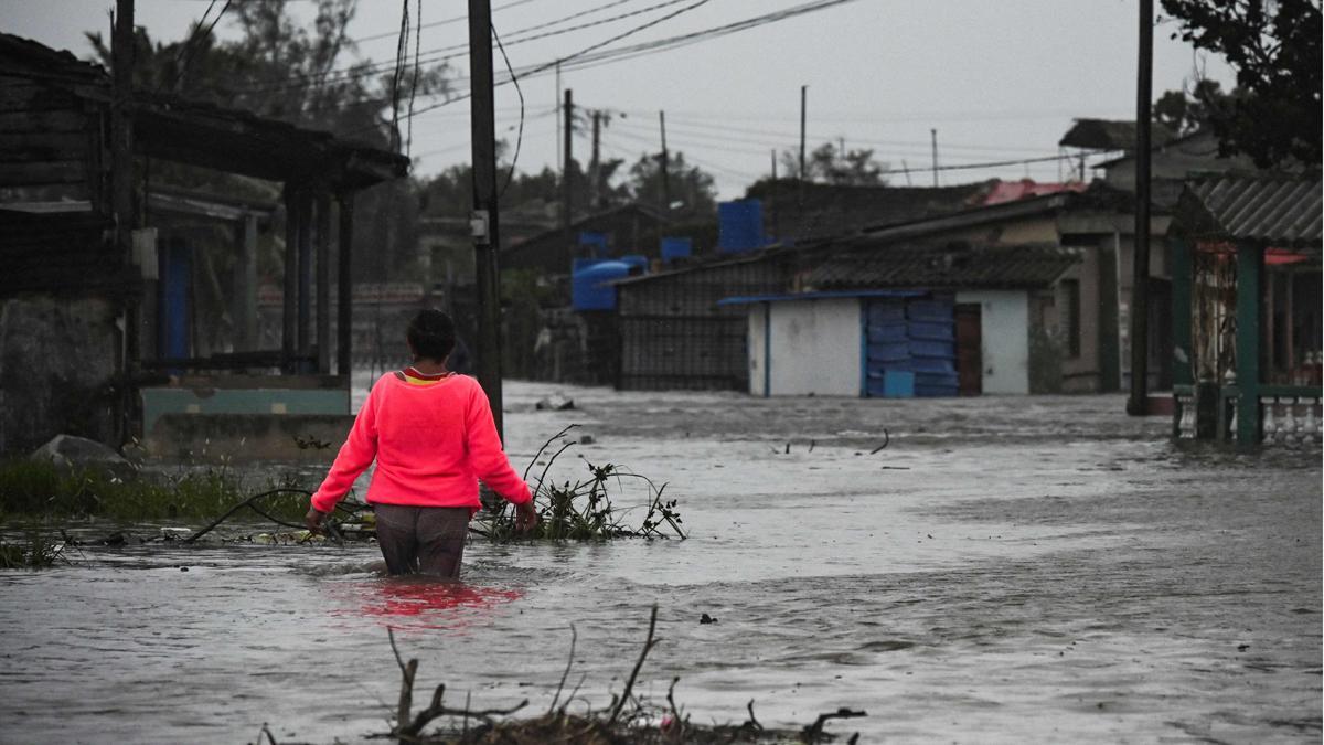 Una mujer camina por una calle inundada en Batabano, Cuba, tras el paso del huracán Ian.