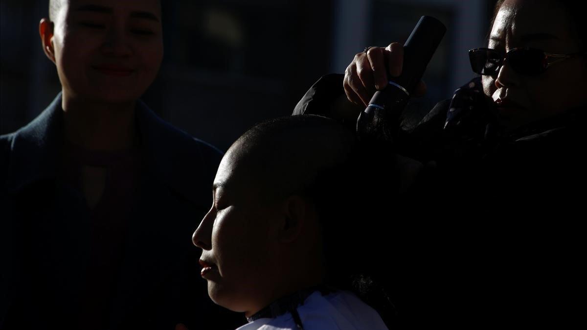 La esposa del abogado Yuan Shanshan se afeita la cabeza como protesta en Beijing.