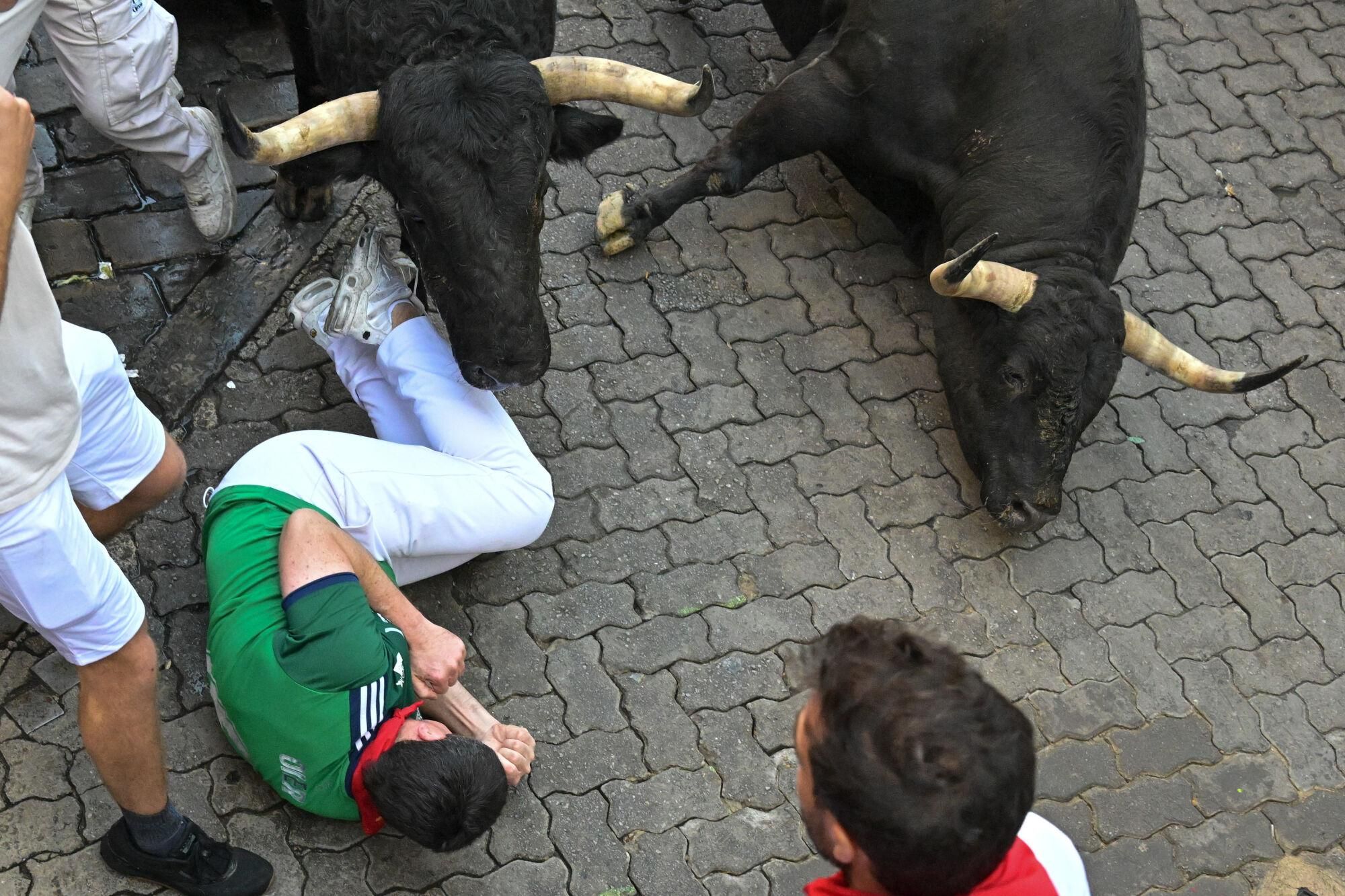 PAMPLONA, 13/07/2025.- Uno de los mozos cae al paso de los toros de la ganadería gaditana de La Palmosilla s durante el séptimo encierro de los Sanfermines 2025 este domingo en Pamplona. EFE/Daniel Fernández