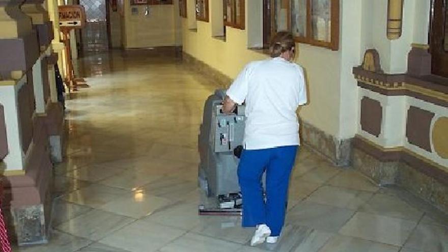 Una trabajadora de Limposam, en sus tareas de limpieza en un pasillo de Ayuntamiento.