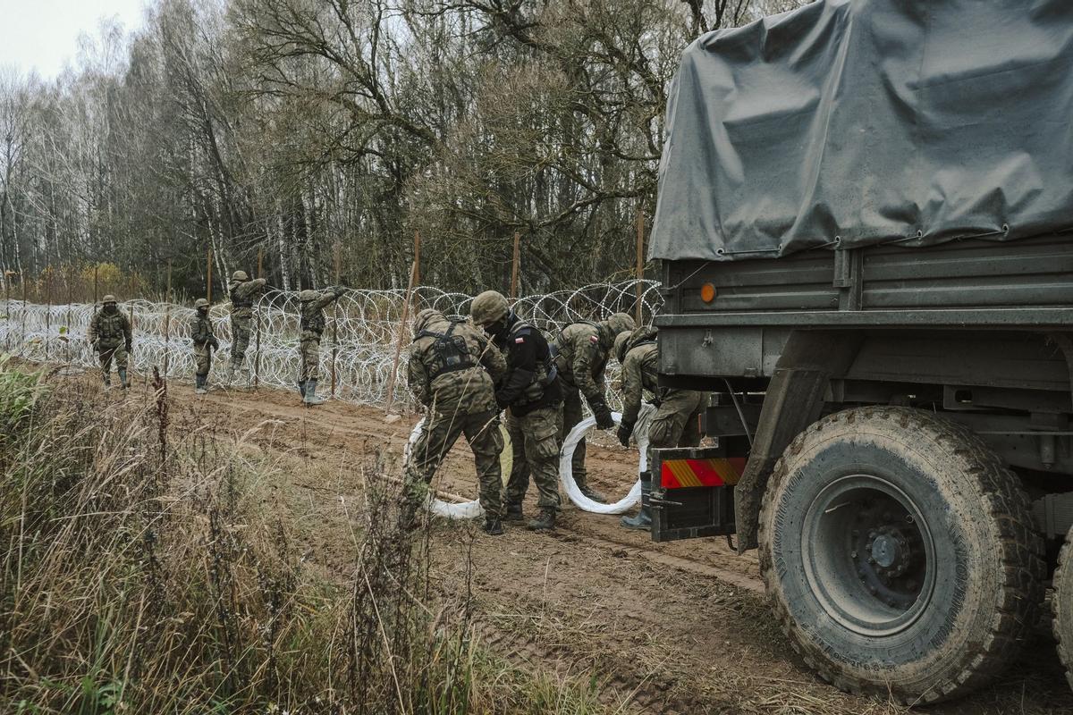 Soldados del ejército polaco arreglan bobinas de alambre de púas en una valla a lo largo de la frontera polaca, con el enclave ruso de Kaliningrado, cerca de Zerdziny, Polonia