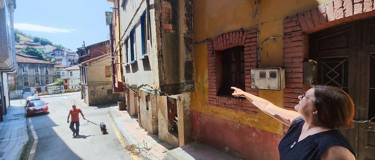 María Ángeles Sánchez señala una grieta en una casa en ruinas en Requejo.