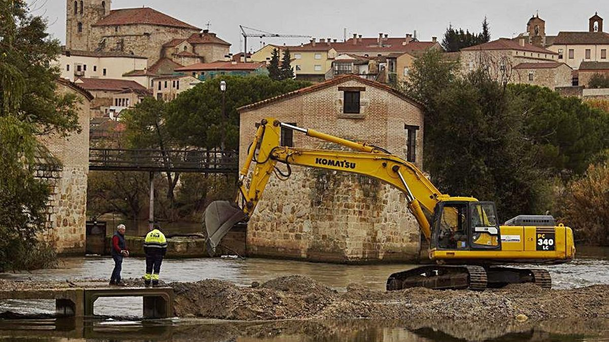 Dos operarios sobre la “ataguía” en construcción. | Jose Luis Fernández