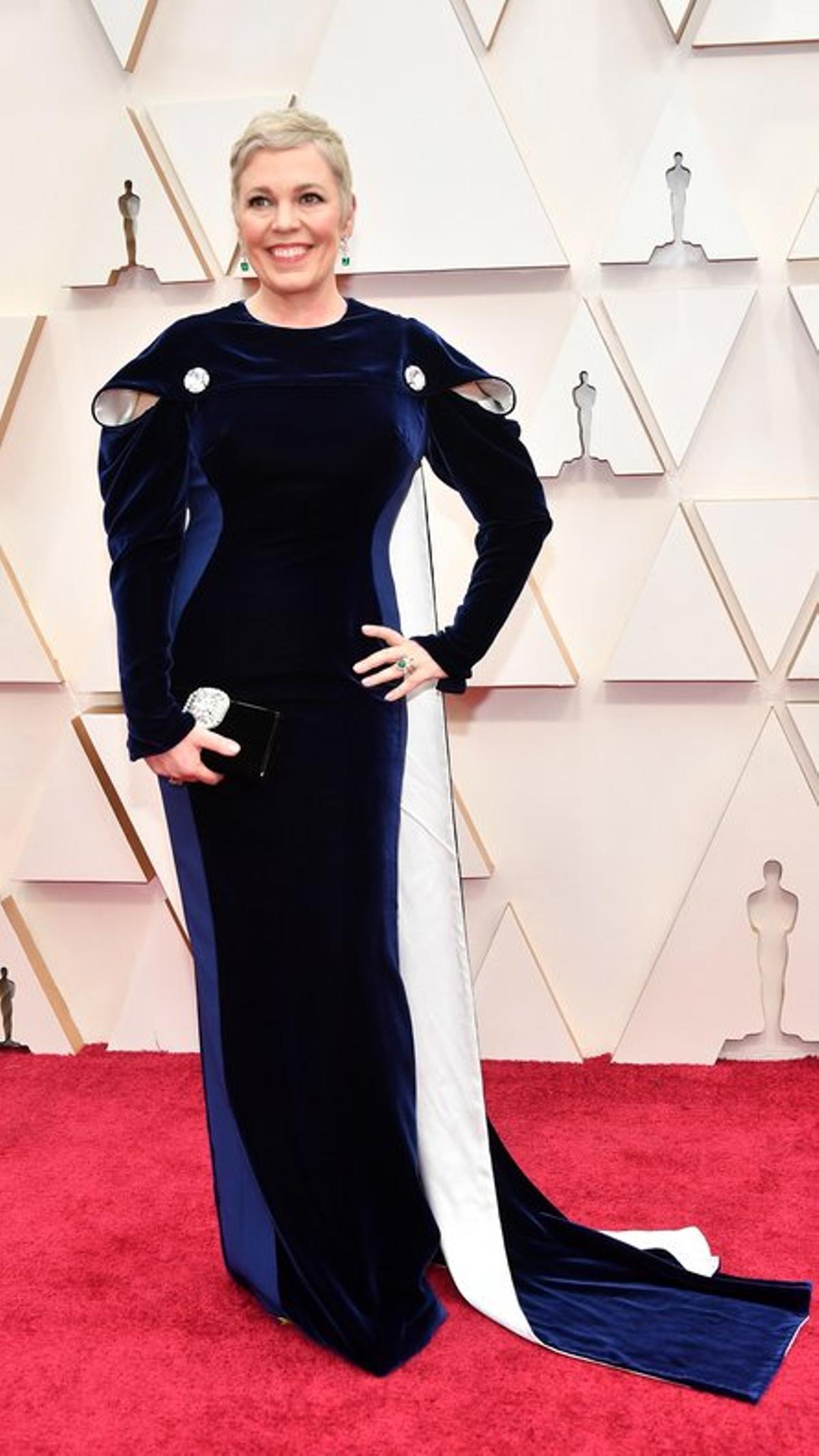 La actriz británica Olivia Coleman, ’The Crown’, ha elegido un vestido de terciopelo tricolor, en dos tonos de azul y blanco, con esmeraldas, de Stella McCartney. 