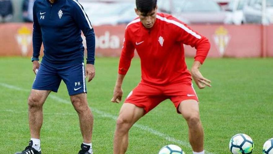 Cristian Salvador controla un balón bajo la mirada de Paco Herrera.