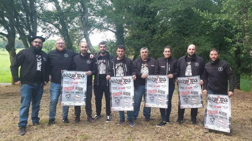 Miembros de la organización del Noceda Rock, con carteles del certamen en la Carballeira de Lamas.