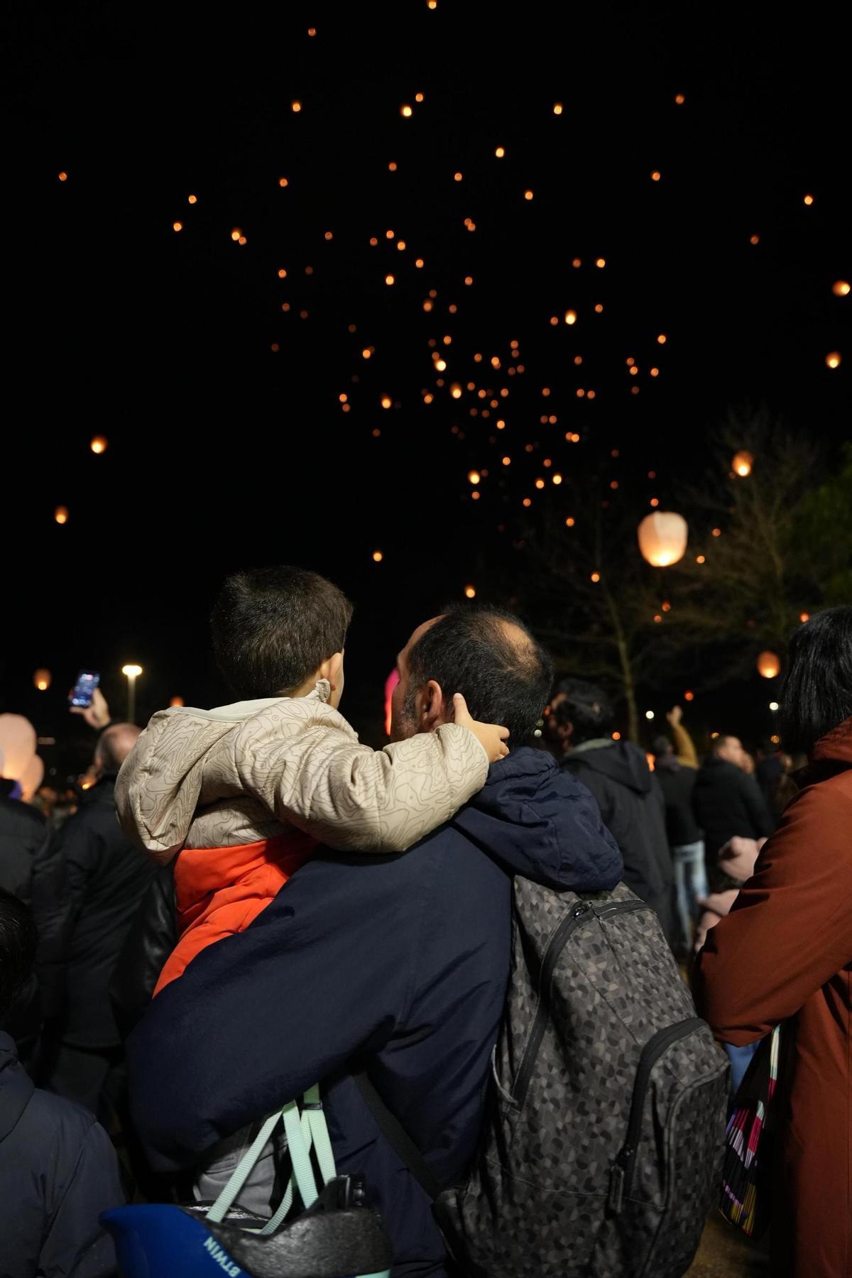 Un padre y su hijo contemplan la estampa que regala La Noche de los Deseos de Badajoz 2025.