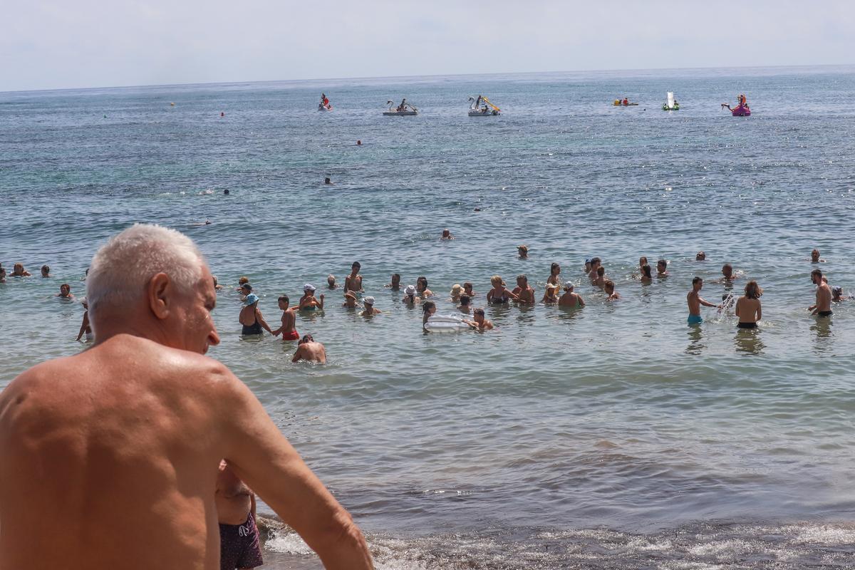 En la playa del Cura cuesta hasta encontrar hueco en el agua en pleno mes de agosto
