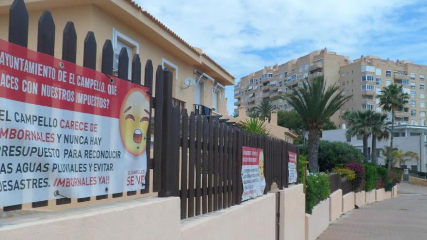 Una urbanización denuncia la falta de servicios en la zona de La Illeta colgando carteles en sus muros