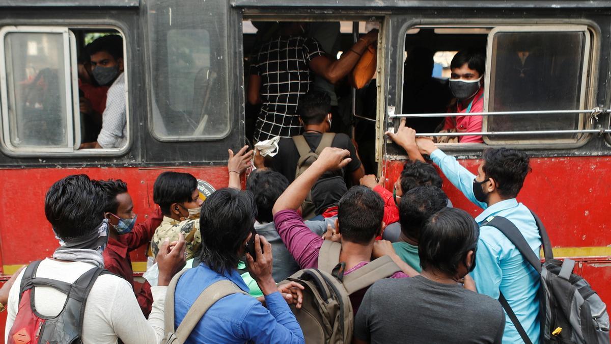 Un grupo de gente se apresura a subir a una autobús en Mumbai (India).