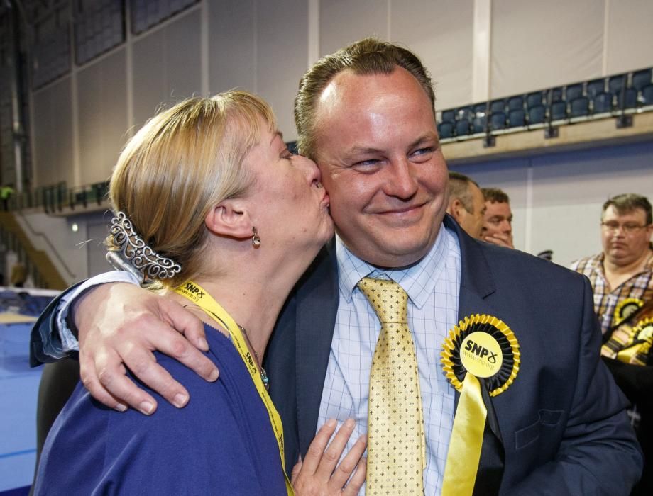El diputado del Partido Nacional Escocés Chris Stephens (d) se encuentra con su esposa, Aileen Stephens (i), después de que ganó el asiento del oeste de Glasgow.
