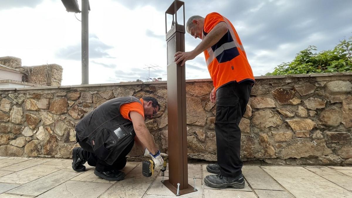 Operaris dels Serveis Municipals instal·lant el darrer punt selfie de la ruta de Blanes, a la plaça de l’Església