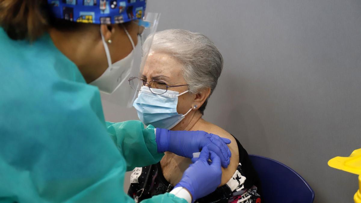 Una mujer recibe la vacuna contra la covid-19 en el  en el Palacio de Ferias y Congresos de Málaga
