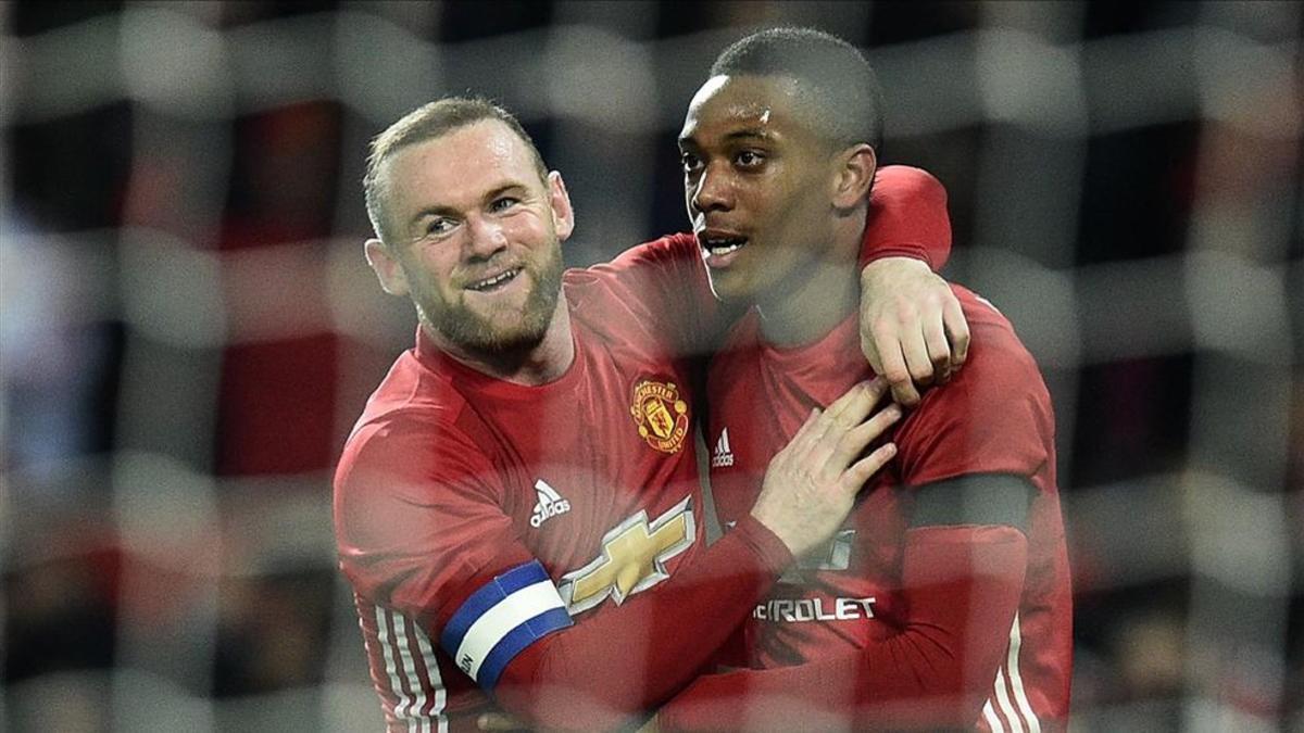 Martial, que marcó dos goles, recibe la felicitación de Rooney tras uno de sus tantos