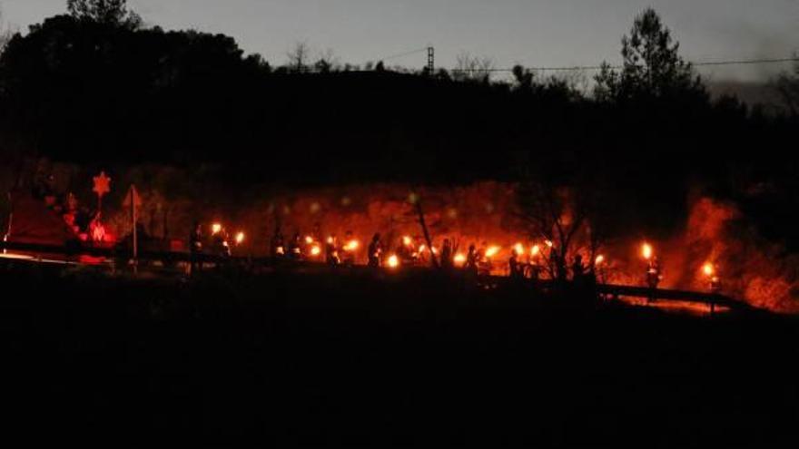 Los Reyes guiados por antorchas por la carretera.