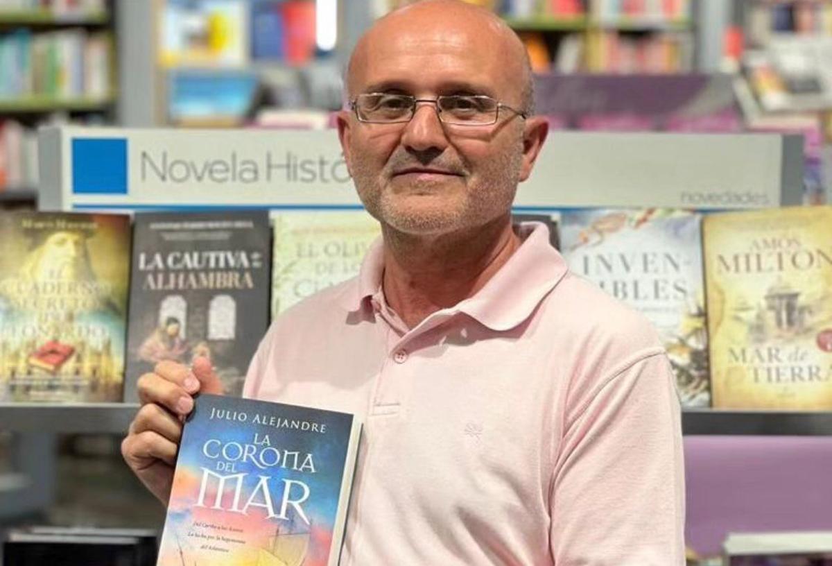 El escritor, Julio Alejandre Calviño, junto a su libro 'La Corona del Mar'.