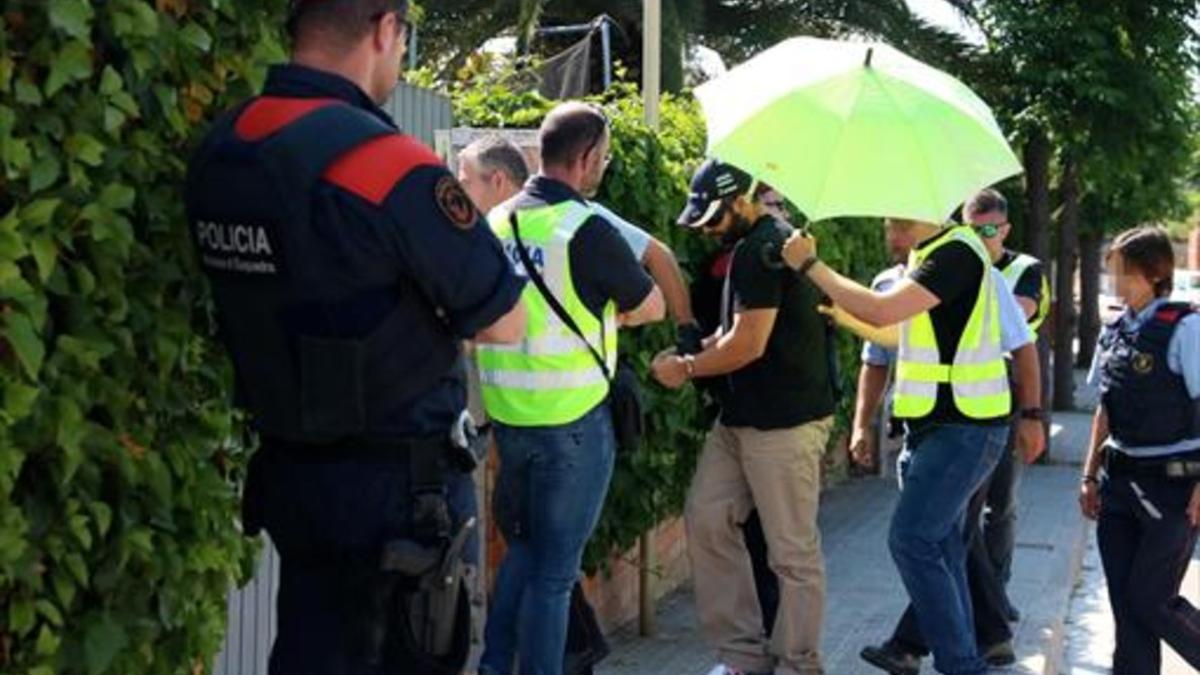 Albert López, esposado (arriba) llega a la casa. Abajo, Rosa Peral, dentro del círculo.