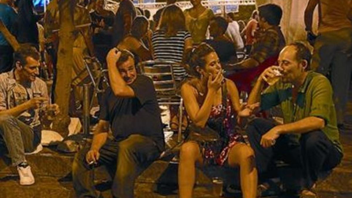 Un grupo de gente sentada bebiendo en Gràcia, la madrugada de ayer.