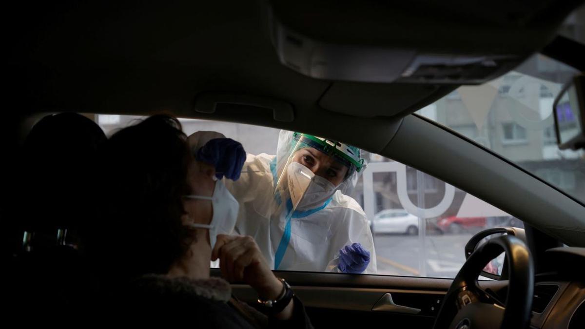 Una sanitaria realiza pruebas PCR en el CovidAuto de O Ventorrillo, esta Nochebuena.   | // CABALAR