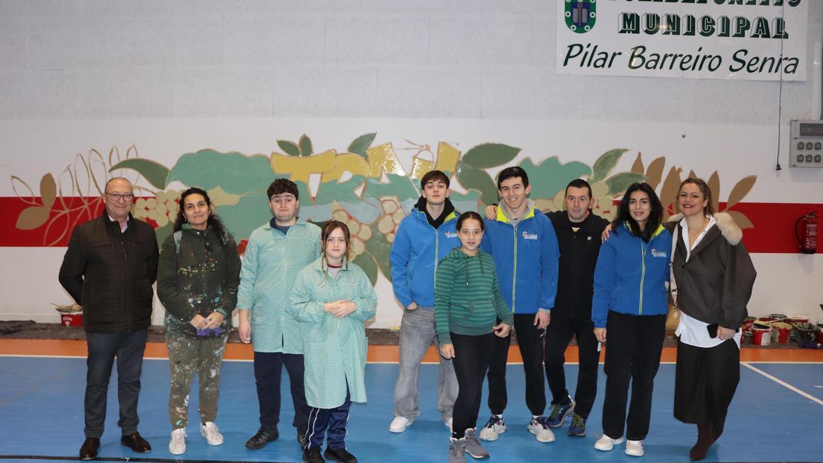 Los seis jóvenes, la monitora y los tres ediles, ante el mural.