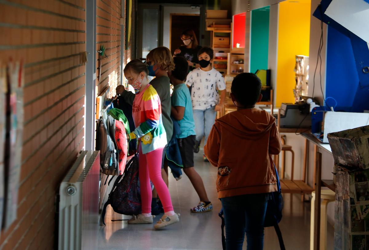 Nens i nenes l'escola rural de l'Estany al passadís penjant les motxilles