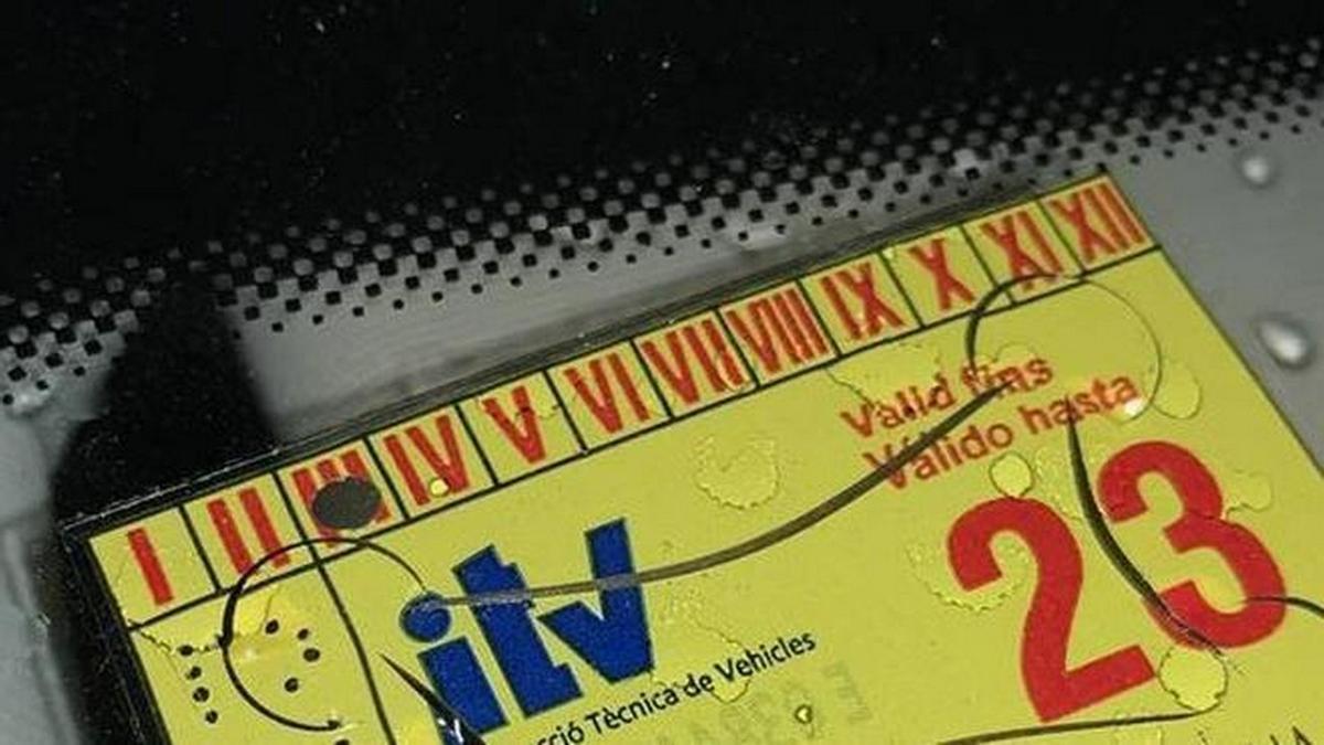 Una pegatina de la ITV en el parabrisas de un coche.