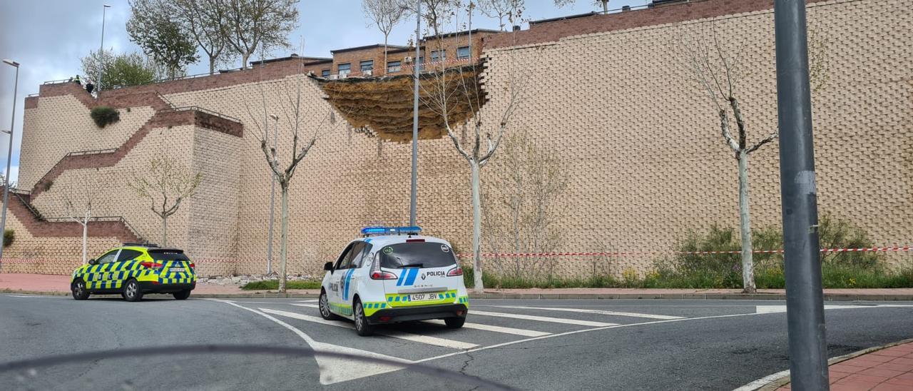 Coches de policía, ante el muro caído.