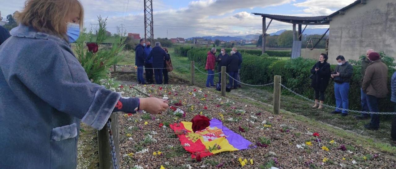 Una de las asistentes al acto deposita una flor sobre la fosa durante el acto en San Miguel de la Barreda. | A. I.