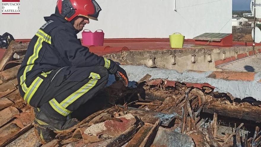 Un bombero superviso los desperfectos que el fuego ha provocado en la cubierta de la vivienda.