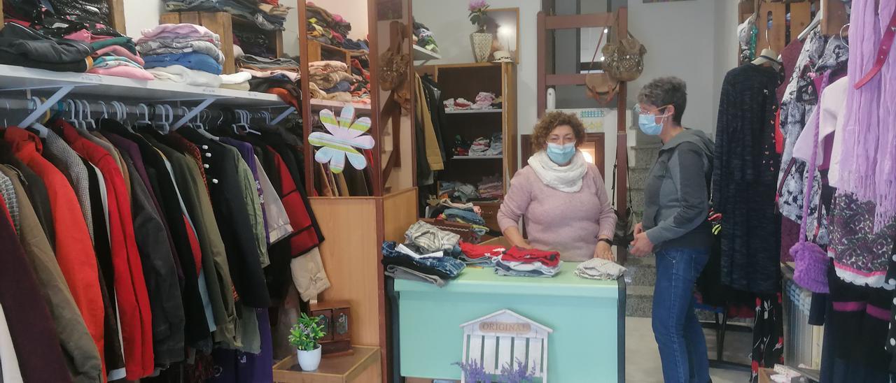 Dos de las voluntarias que atienden en el ropero municipal de Miño, acondicionado a modo de boutique