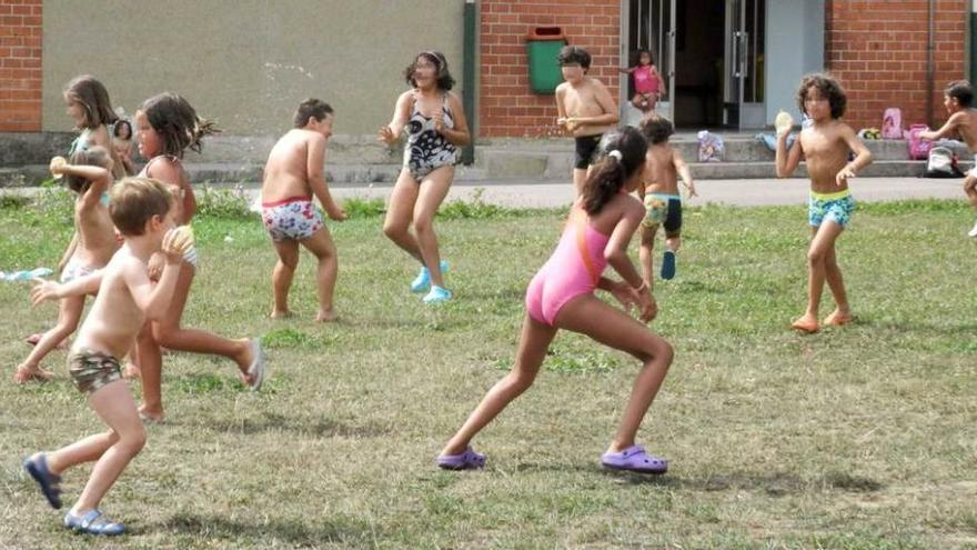 Los niños que participan en la colonia, ayer, en plena batalla de globos de agua.