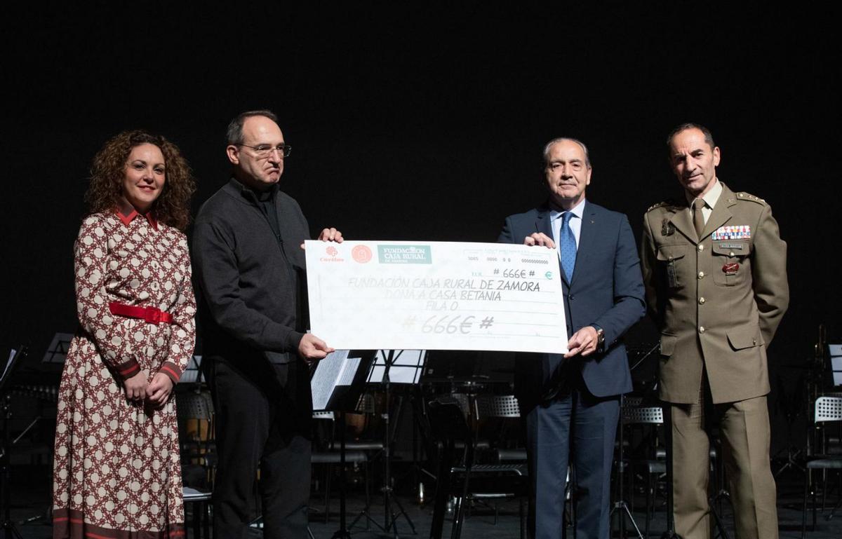 Cipriano García entrega en cheque de la «fila cero» de Caja Rural a Antonio Jesús Martín de Lera (Cáritas) y Beatriz Carracedo (Casa Betania), en presencia del coronel Vicente González. | Ana Burrieza