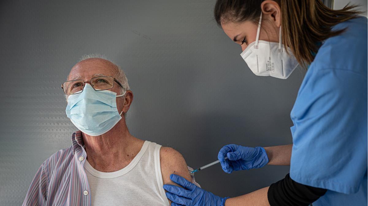 Una sanitaria vacuna a un paciente contra el covid-19, en Barcelona. 