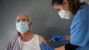 Una sanitaria vacuna a un paciente contra el covid-19, en Barcelona. 