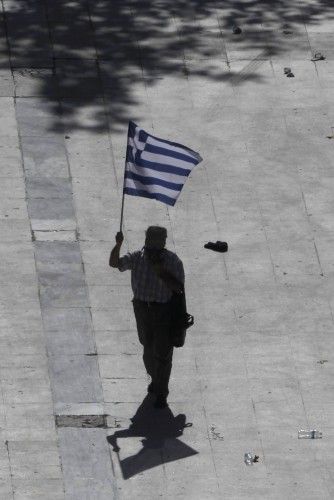 Man walks with a Greek flag at a protest march by Greece's Communist party in central Athens during a 24-hour labour strike