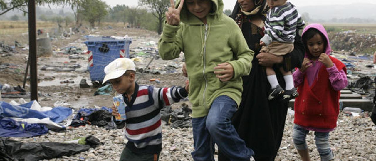 Una madre y cuatro hijos cruzan un camino próximo a las vías del tren en Gevgelija (Macedonia).