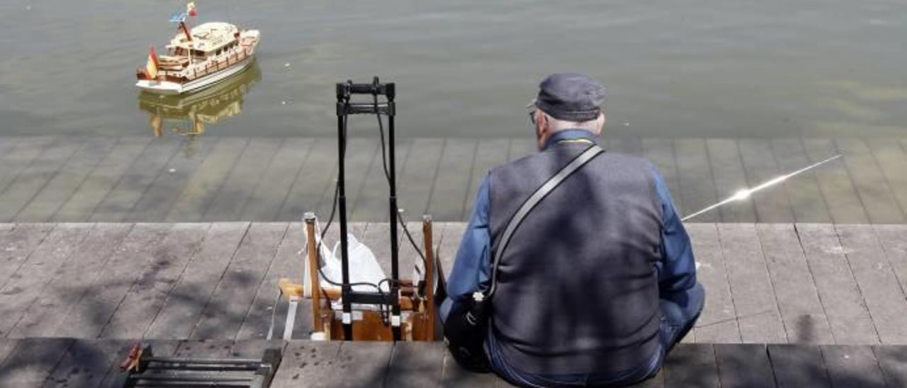 Un anciano juega con un barco de radiocontrol en el Parque de Cabecera.