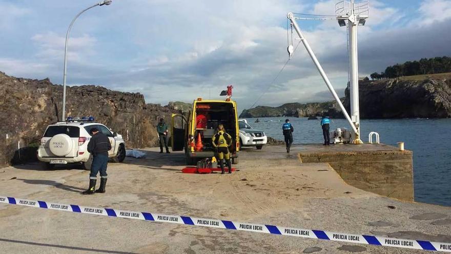 El cuerpo sin vida del llanisco -detrás del vehículo de la izquierda, cubierto con una manta-, ayer, en el puerto de Celoriu.