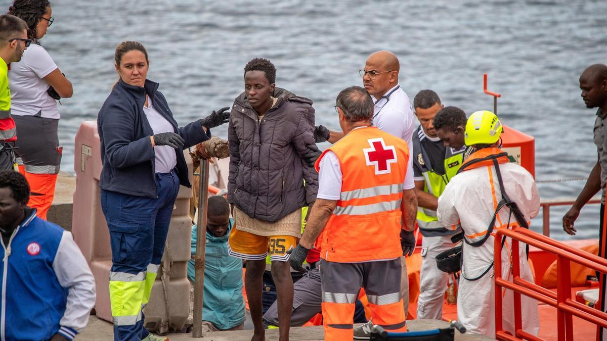 Varias personas salen de un cayuco, en el muelle de La Restinga
