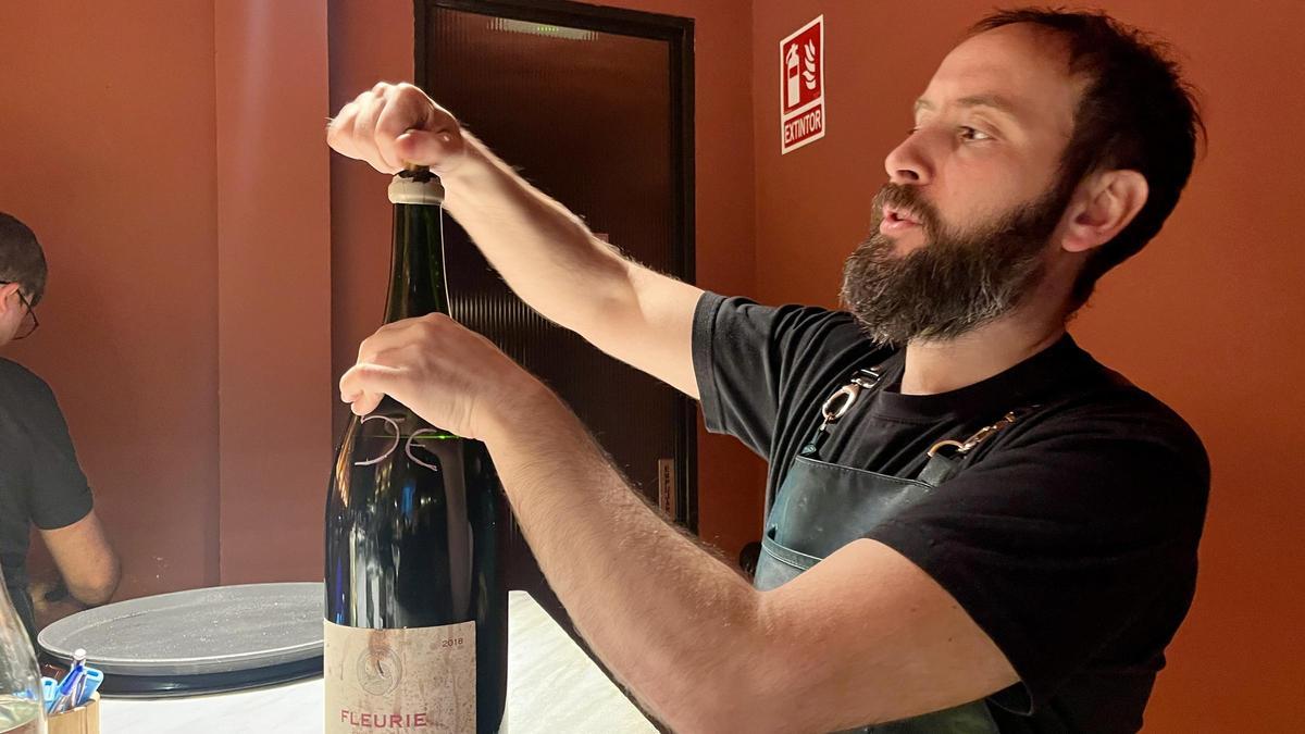 David Villalón, abriendo una botella de tres litos de Beaujolais.
