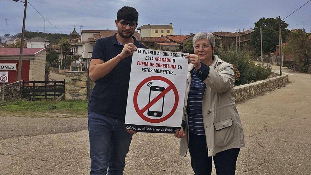 El alcalde, Santiago Moral, y la concejala de Ufones, Marga López, con uno de los carteles de la campaña "Pueblo apagado"