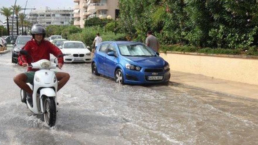Un motorista pasa con cuidado por una calle inundada de Talamanca.