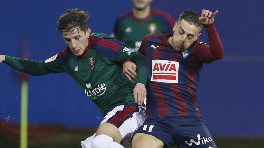 Peña, del Eibar, lucha con Tano, del Osasuna.