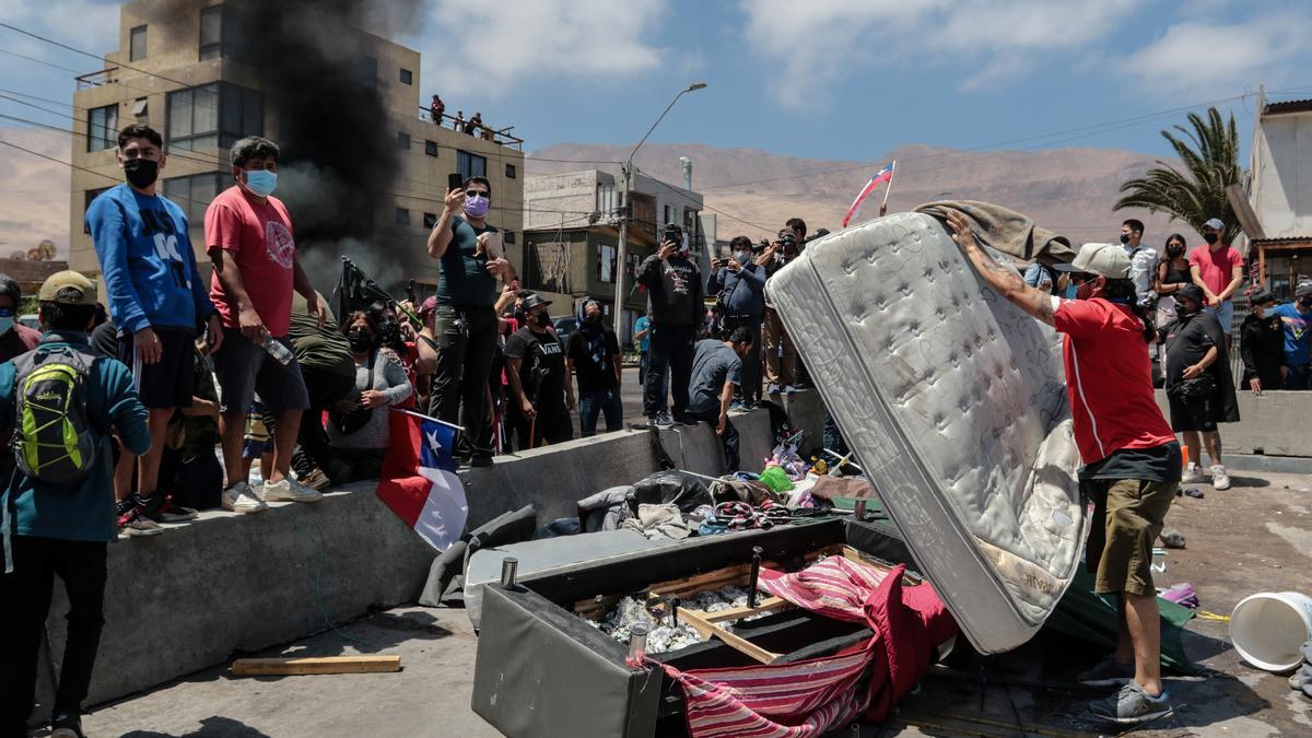 Un grupo de personas quema carpas utilizadas por extranjeros para pernoctar en plazas y playas, durante una marcha contra la migración irregular en Iquique.