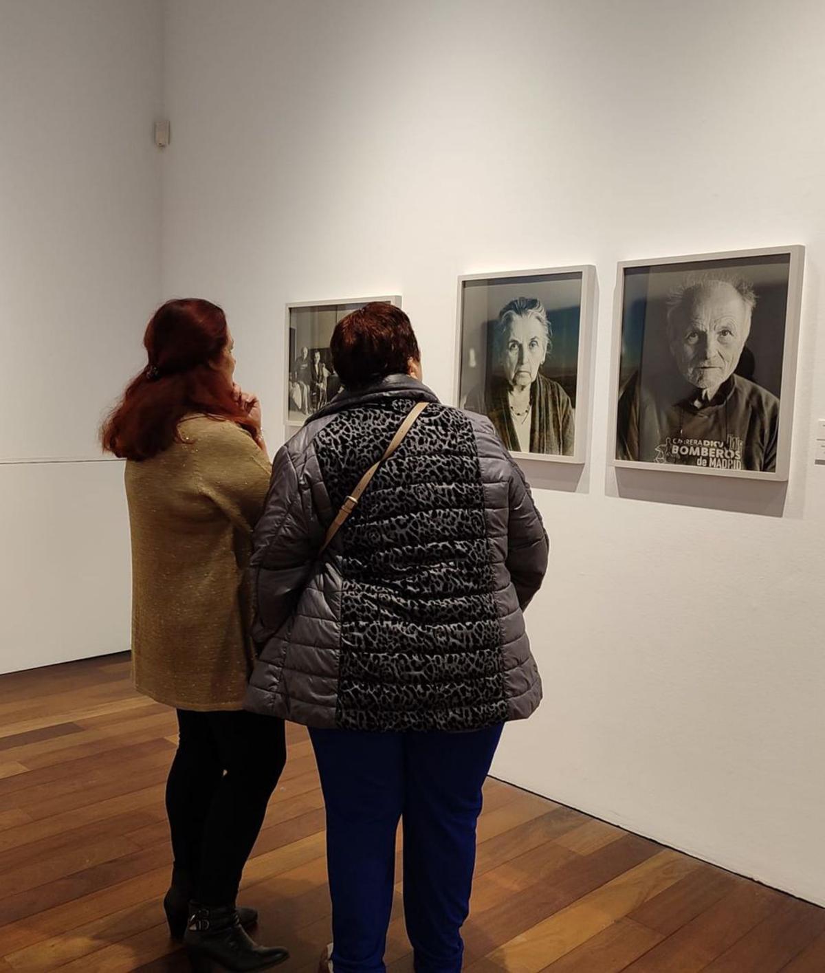 Dos mujeres contemplan fotogafías de Carnero. | L.O.Z.