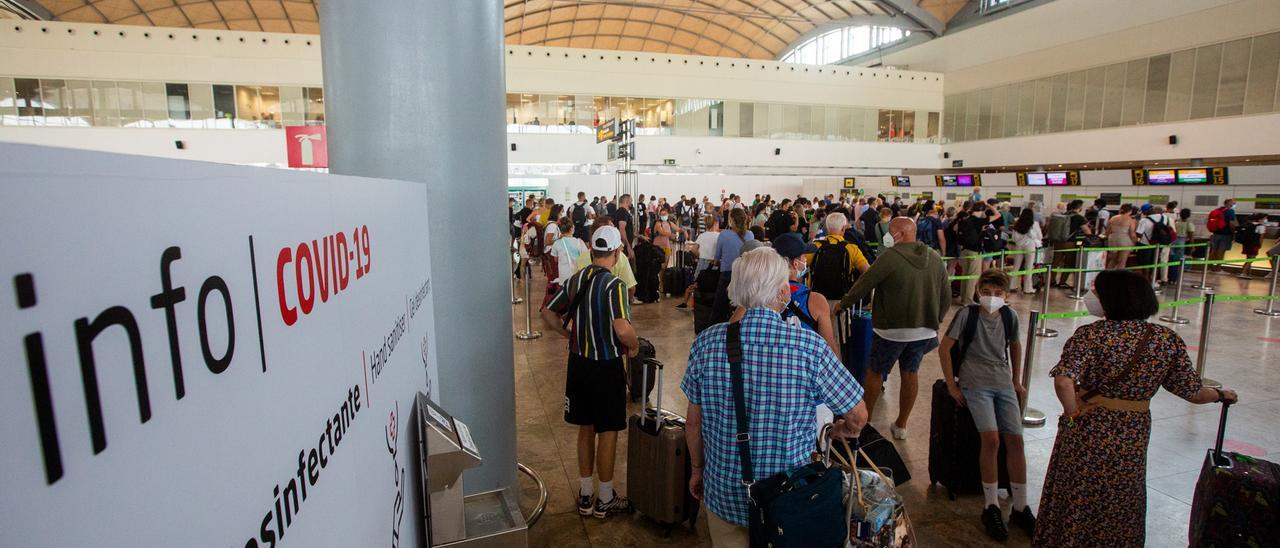 Pasajeros esperan en cola para facturar, ayer, en el aeropuerto de Alicante-Elche.