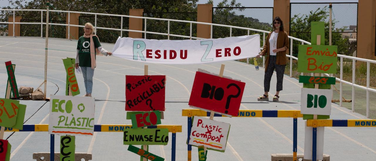 Dos miembros de los grupos ecologistas aguantando la línea de meta con el lema ‘Residuo Cero’.