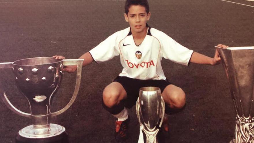 Pablo Marí posa junto al triplete del Valencia CF logrado en 2004 cuando estaba en las inferiores de la entidad valencianista.