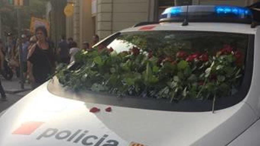 Un cotxe dels Mossos, amb flors, el dia de la manifestació.