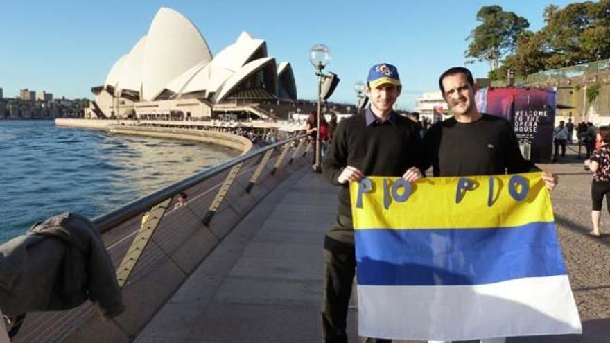 José Manuel Díaz (d), junto al aficionado tinerfeño de la UD Ehedei Galán, muestra una bandera de Gran Canaria. Detrás, la Opera House de Sídney. | lp / dlp